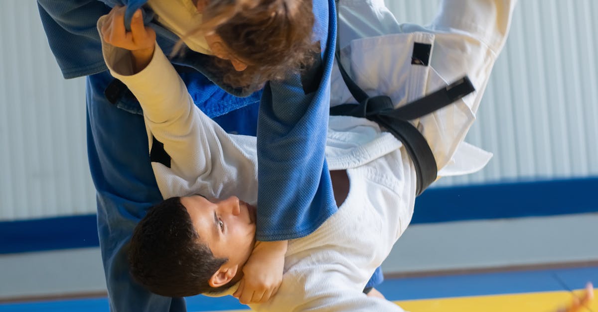Two judokas in intense training, executing a dynamic throw on a dojo mat.